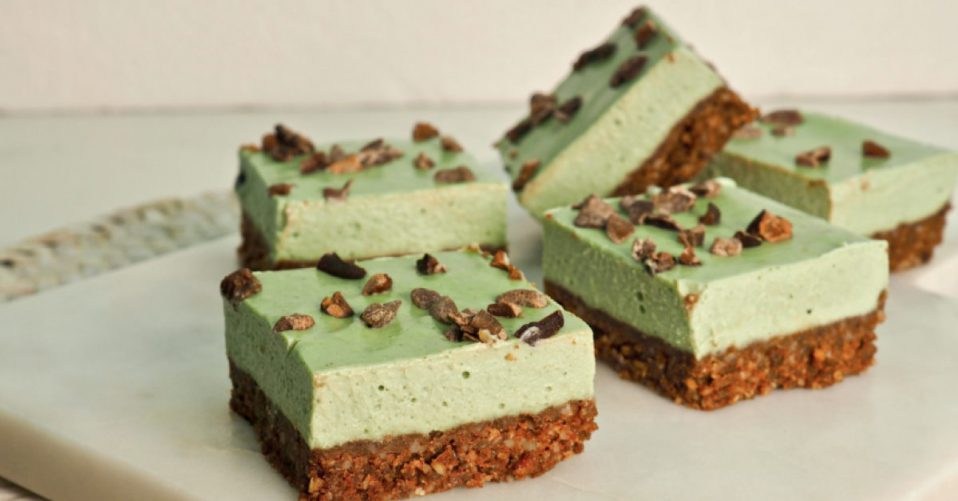 Slice squares on a plate that have a choclately nutty looking base and a creamy mint green top