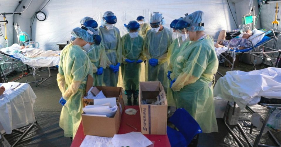 Medical crew gather to pray inside the Emergency Field Hospital in Cremona, Italy